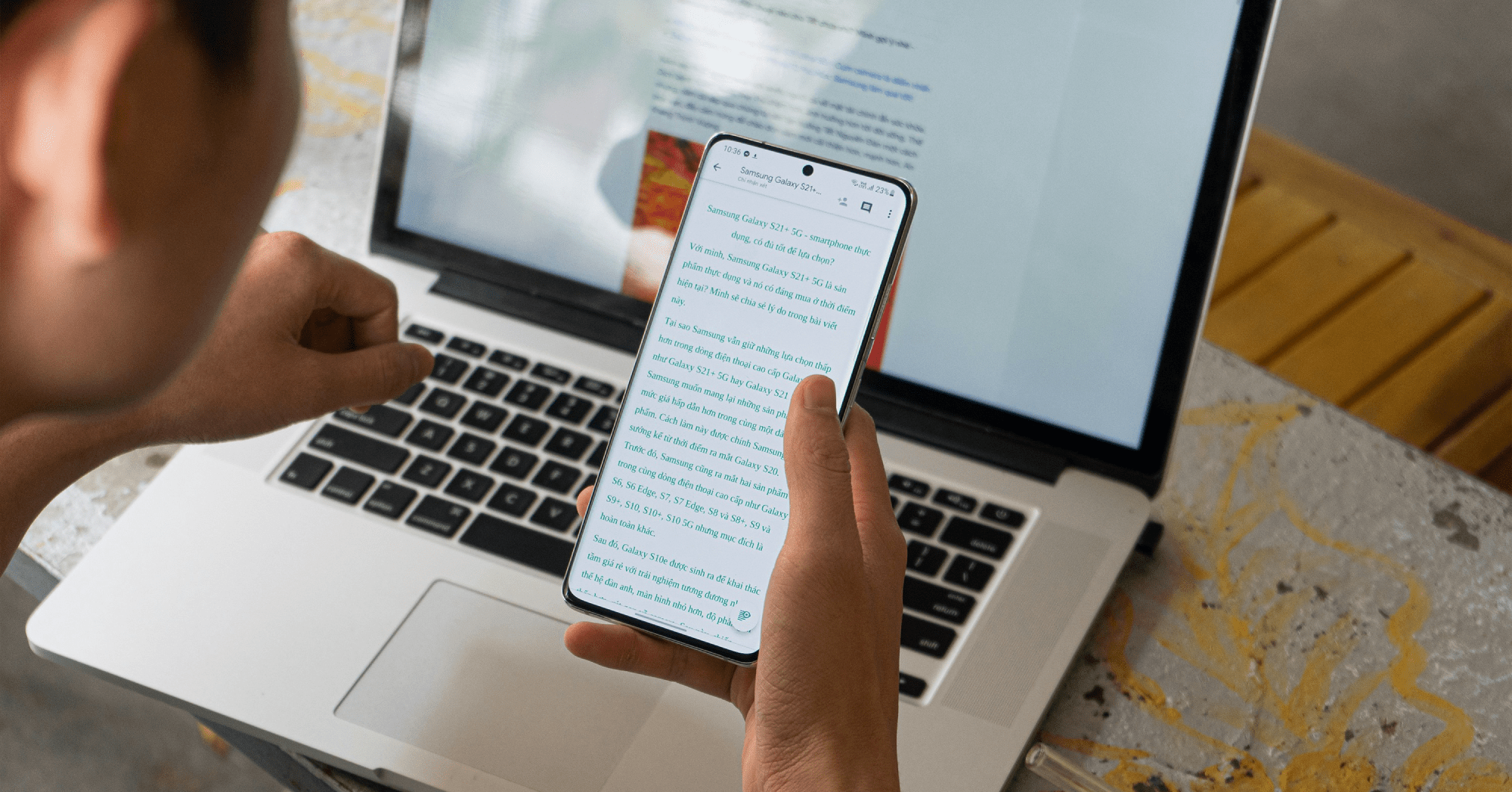 Person journaling on phone and laptop—AI-powered digital journaling in action.